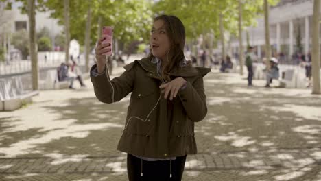 mujer joven feliz hablando por teléfono al aire libre durante un día soleado.