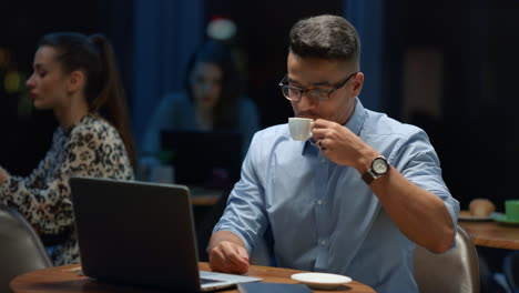 Businessman-video-calling-online-with-partner-in-cafe.-Man-drinking-coffee