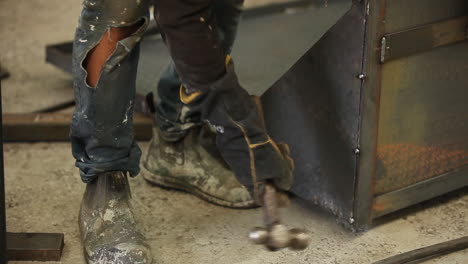 steel worker using heavy hammer mallet to ensure the best smooth edge can be presented