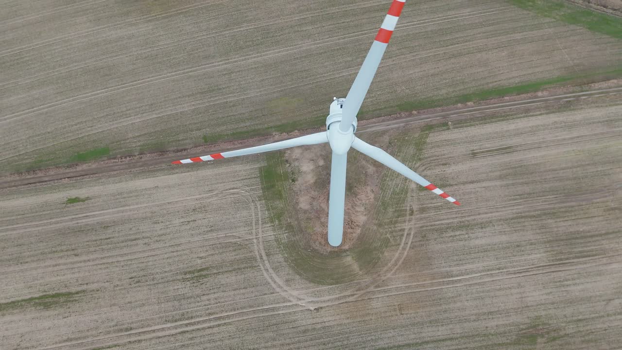 Drone shot of an electric powermill changing view from top-down to bottom-up.