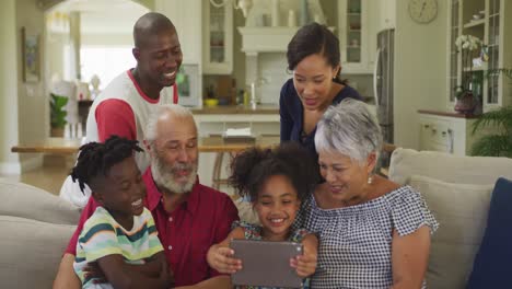 familia de tres generaciones usando tableta digital en el hogar