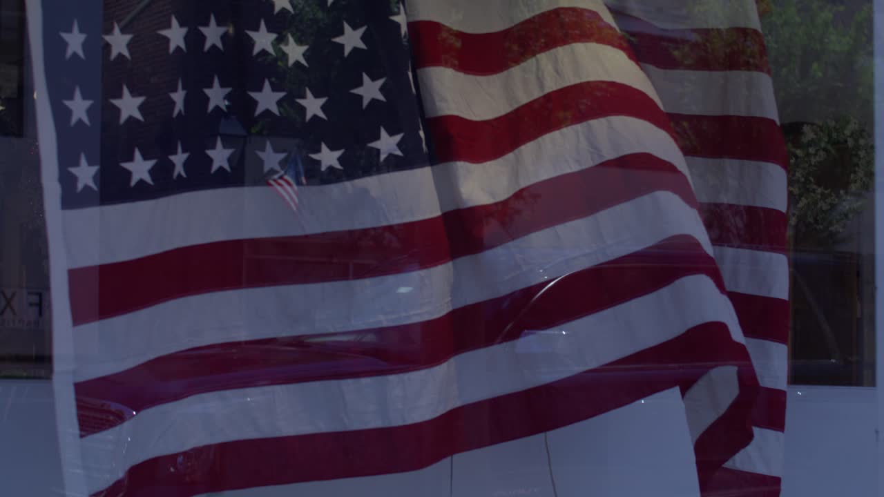 American flags flying in the wind in front of stores in downtown Fredericksburg, Virginia with gimbal video in slow motion