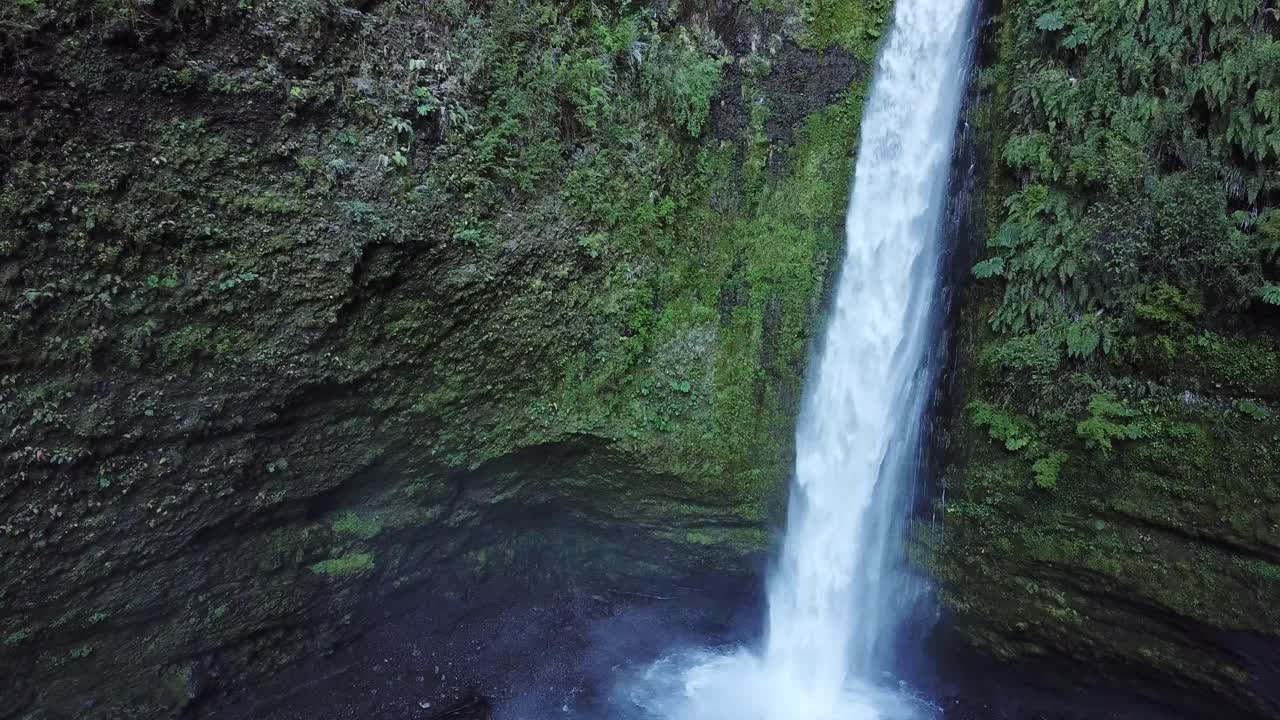 Close Up Aerial of Waterfall Deep in Jungle of Volcanic Mountains