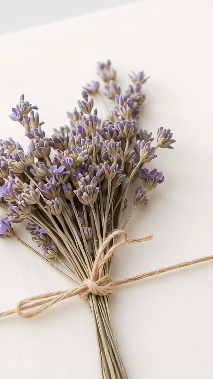 Video verticale: la camera inizia a zoomare verso l'alto su un biglietto color crema, mostrando la lavanda con lo spago per dare consistenza