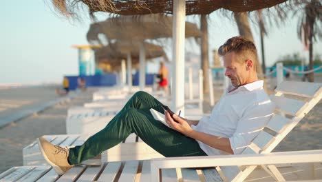 Businessman-surfing-on-smartphone-on-beach