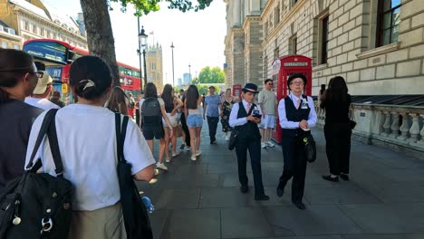 people walking past iconic red telephone box