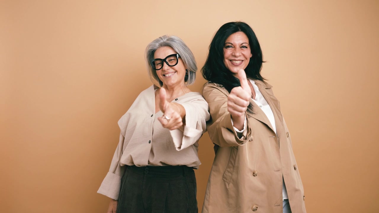 Two Mature Women Smiling and Giving Thumbs Up