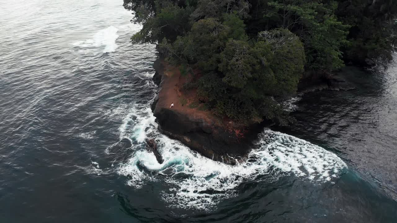 Blue Sea With Strong Waves Breaking On The Rocky Cliffs With Lush Green Trees In Costa Rica  -  aerial drone shot