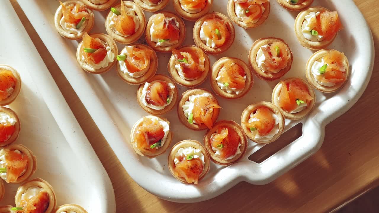 Tartelettes au saumon joliment présentées, avec du fromage frais, des herbes et un service traiteur élégant