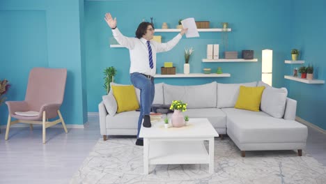 el hombre gracioso celebra el éxito en el trabajo en casa con el baile.