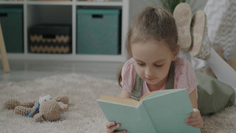 girl reading a book on the carpet