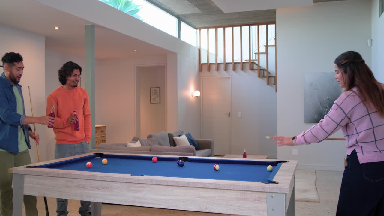 Celebrating shot at home Diverse friends high-fiving and watching cue ball scattering on pool table