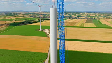 construcción de turbina eólica con trabajador en la torre en austria - toma aérea de dron