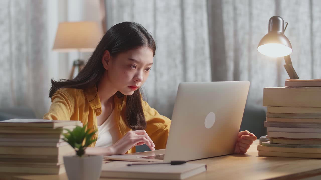 밤에 집에서 공부하는 젊은 여성