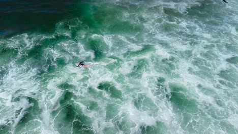 girl surfer swims through white water