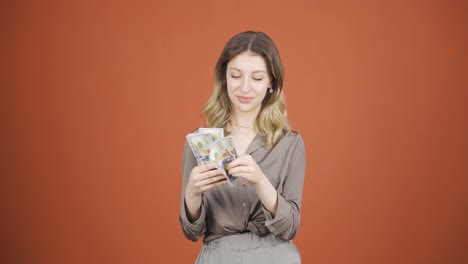 young woman counting money looking at camera.