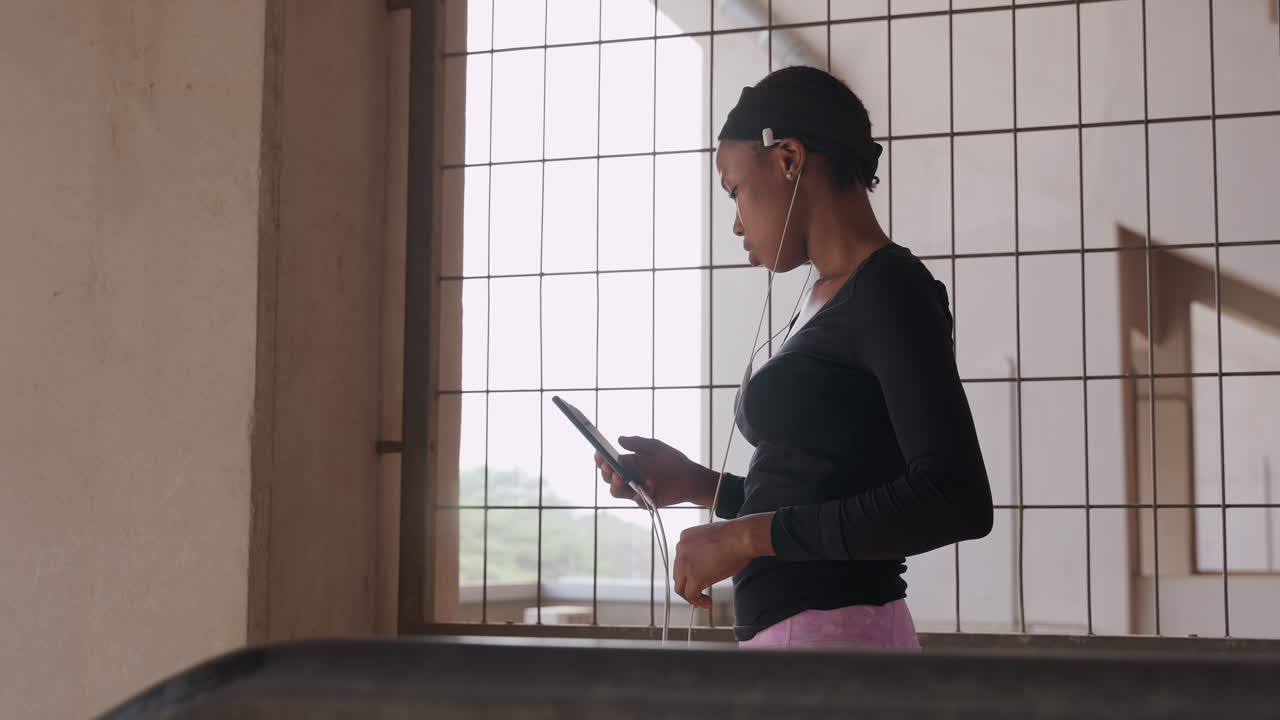 Woman simulating speech. Young lady preparing her speech. Young woman rehearsing speech using gestures by window. Girl meticulously practicing her speech and gestures in front of window