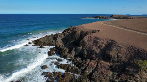 Fly-Over-Rocky-Shore-Of-Emerald-Beach-Headland-In-Emerald-Beach,-NSW-Australia