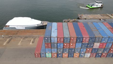 Jacht-Vor-Anker-In-Der-Nähe-Eines-Stapels-Intermodaler-Container-Im-Industriellen-Containerhafen-In-Dordrecht,-Niederlande