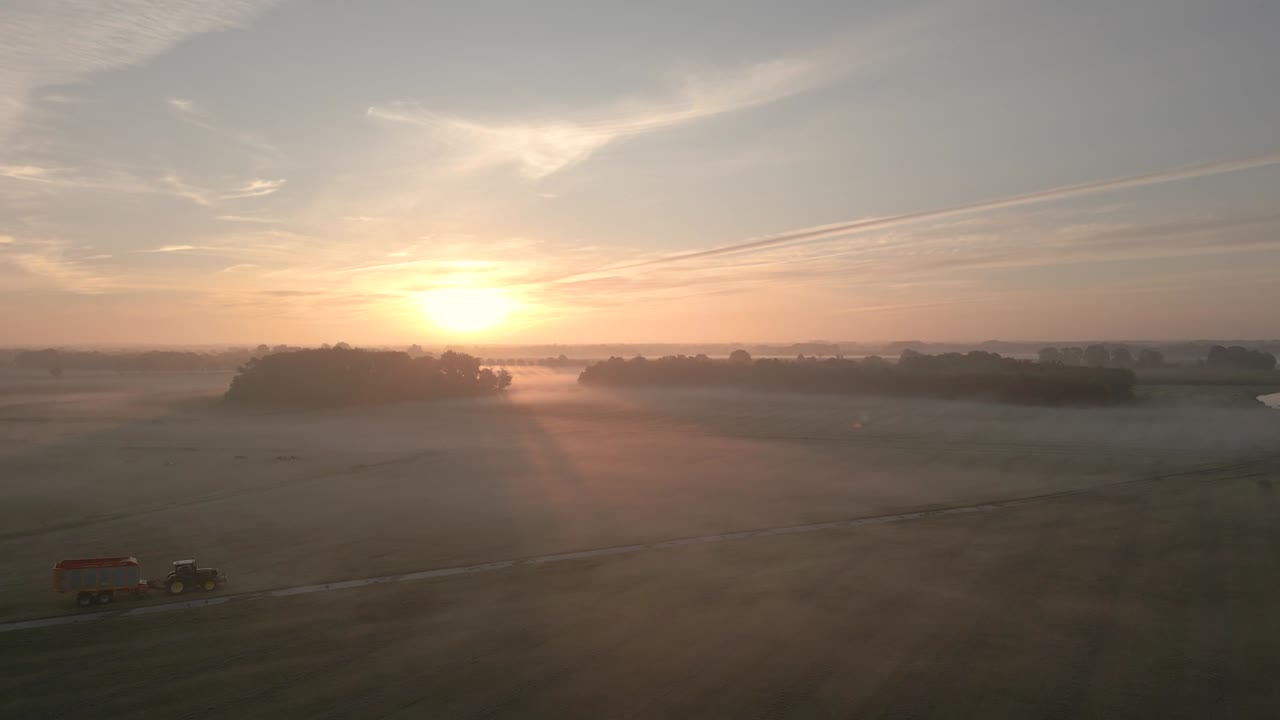 Misty Sunrise over Farmland with Tractor