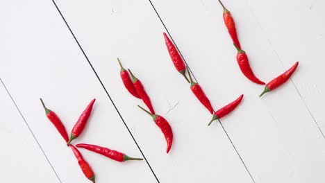 A-word-KILL-formed-with-small-red-chilli-peppers--Placed-on-white-wooden-table