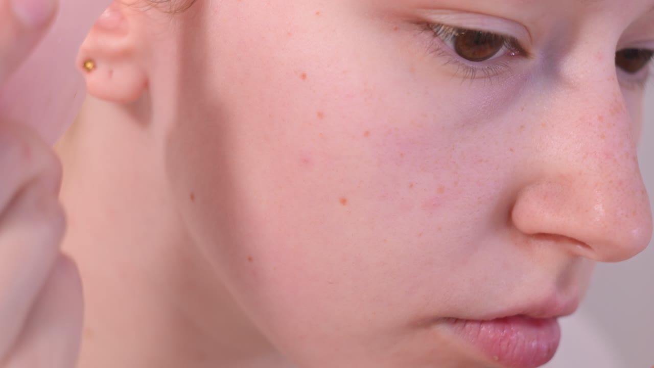 Girl with rose quartz gua sha doing facial massage. Macro close up