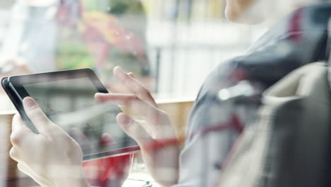 Primer-Plano-Manos-De-Mujer-Usando-La-Pantalla-Táctil-De-La-Tableta-Ipad-En-La-Cafetería