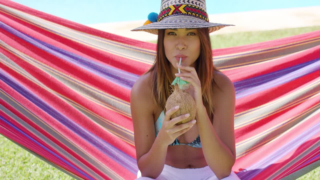 코코 음료 를 마시고 햄록 에 앉아 있는 여자