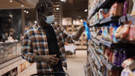 african american guy taking products from the shelf in the supermarket