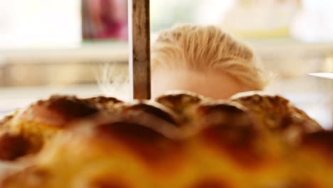 young woman looking through bakery window