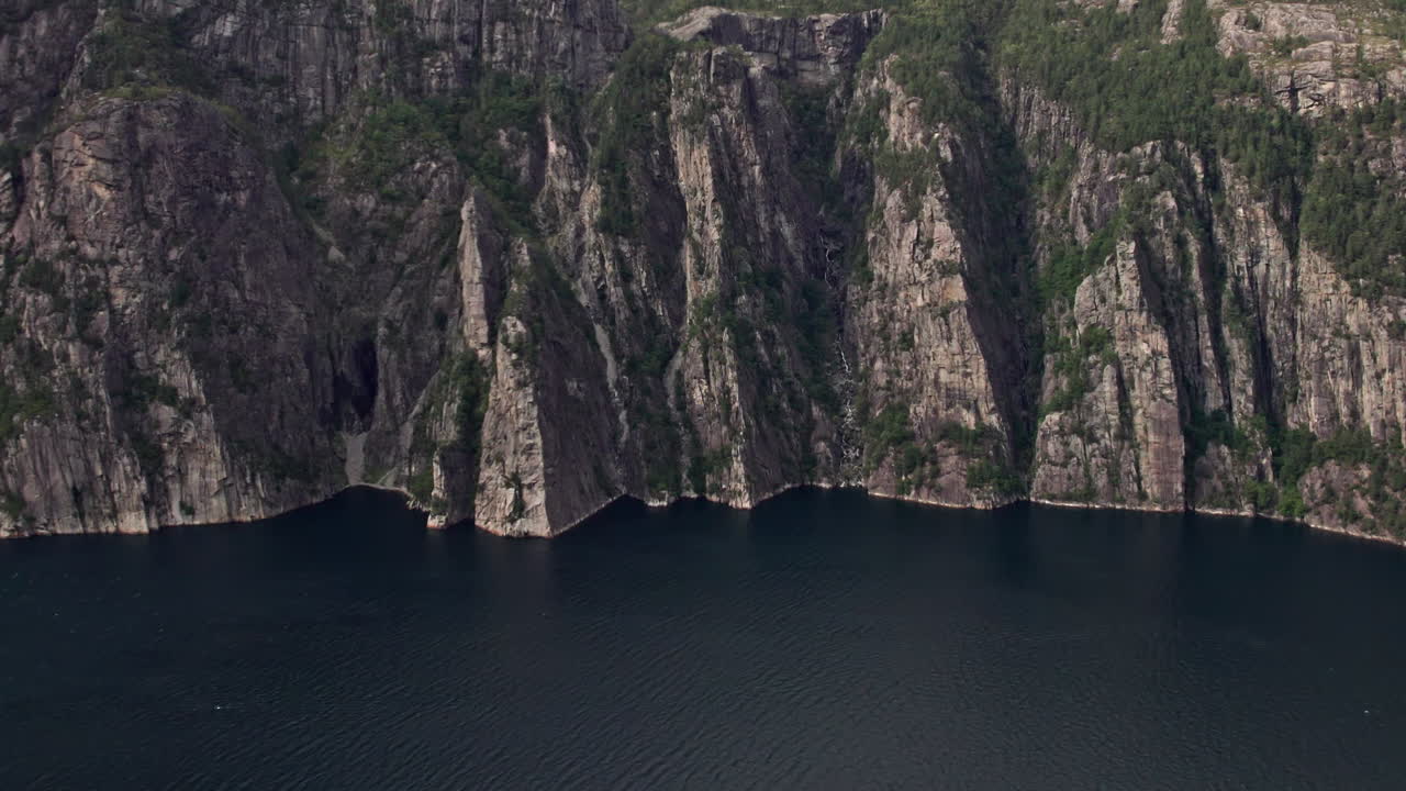 Aerial shot, pushing in on the cliffs beneath Preikestolen, by Lysefjord in Norway