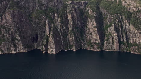 Toma-Aérea,-Avanzando-Hacia-Los-Acantilados-Debajo-De-Preikestolen,-Junto-Al-Fiordo-De-Lysefjord-En-Noruega.