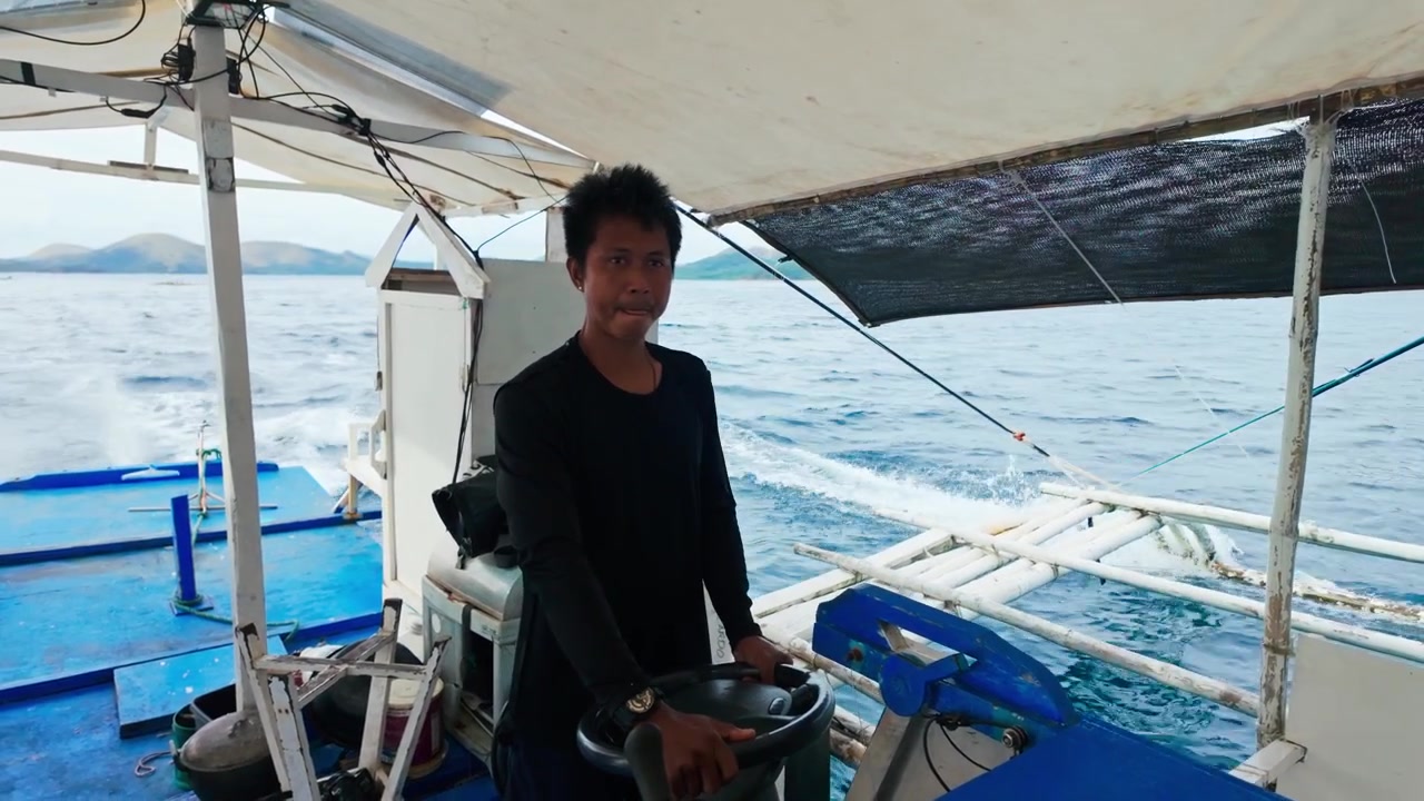 Philippinischer Kapitän navigiert eine traditionelle Banca durch die malerische Meereslandschaft von Palawan