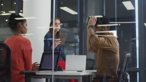 Mixed-race-businessman-taking-off-vr-headset-during-meeting