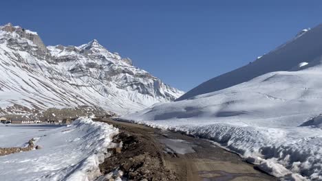 narrow road and snow covered mountains of himachal pradesh in india - wide shot