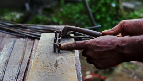 carpenter in india black male skilled hands close up bending construction iron steel rond manually