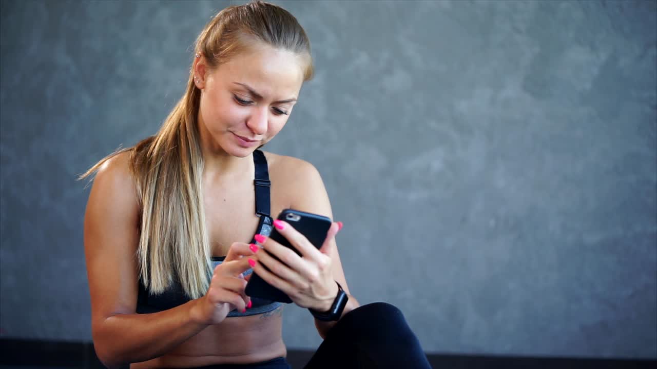 Woman checking phone in gym