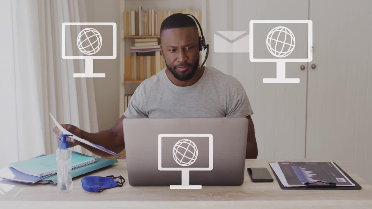 Animation of screens with globes icons over african american man using laptop
