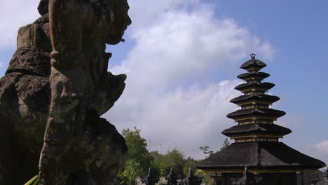 una estatua de un dios balinés mira hacia el complejo del templo besakih en bali, indonesia