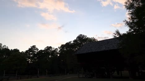 lapso de tiempo de la puesta de sol sobre una fábrica de algodón en una granja