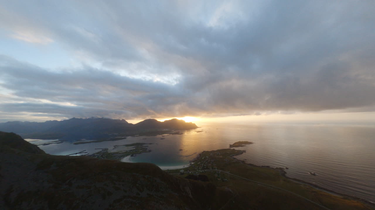 fpv revela la playa de rambergstranda en una noche dorada de puesta de sol, las islas lofoten en noruega, impresionante vuelo cercano