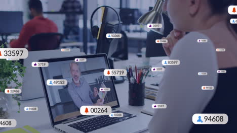 animación de iconos de las redes sociales contra una mujer caucásica haciendo una videollamada en una computadora portátil en la oficina