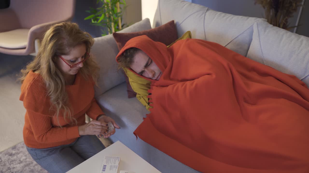 어머니는 아픈 아들에게 약을 줍니다.