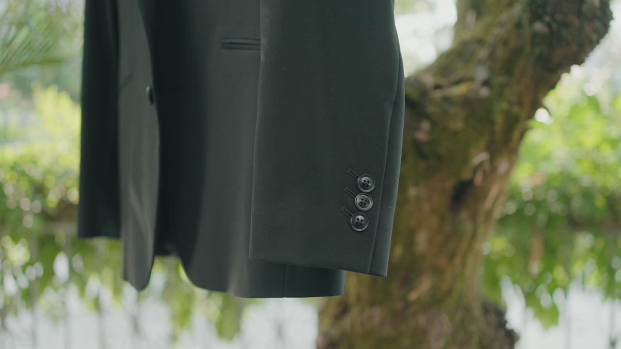 close up of elegant black suit jacket sleeve with buttons outside