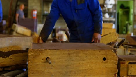 Worker-removing-metal-rod-from-molds-in-workshop-4k