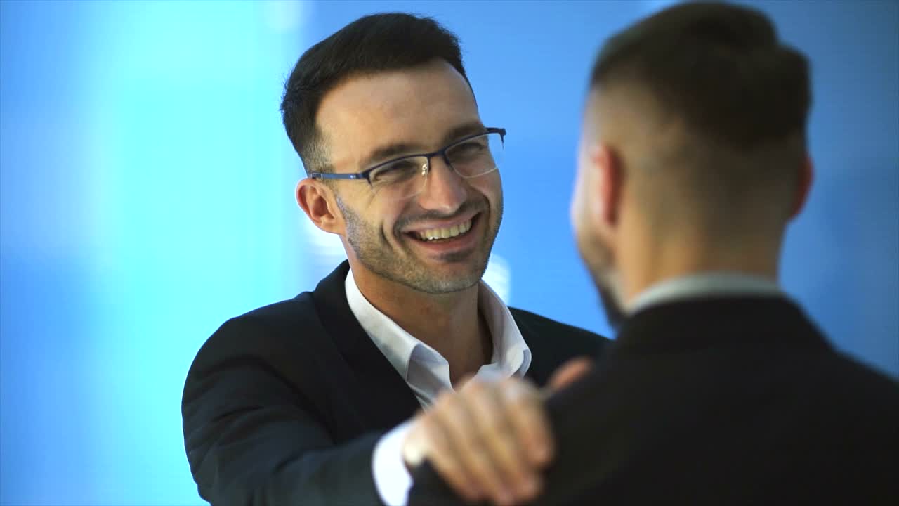 The two happy men talk on the blue background. slow motion