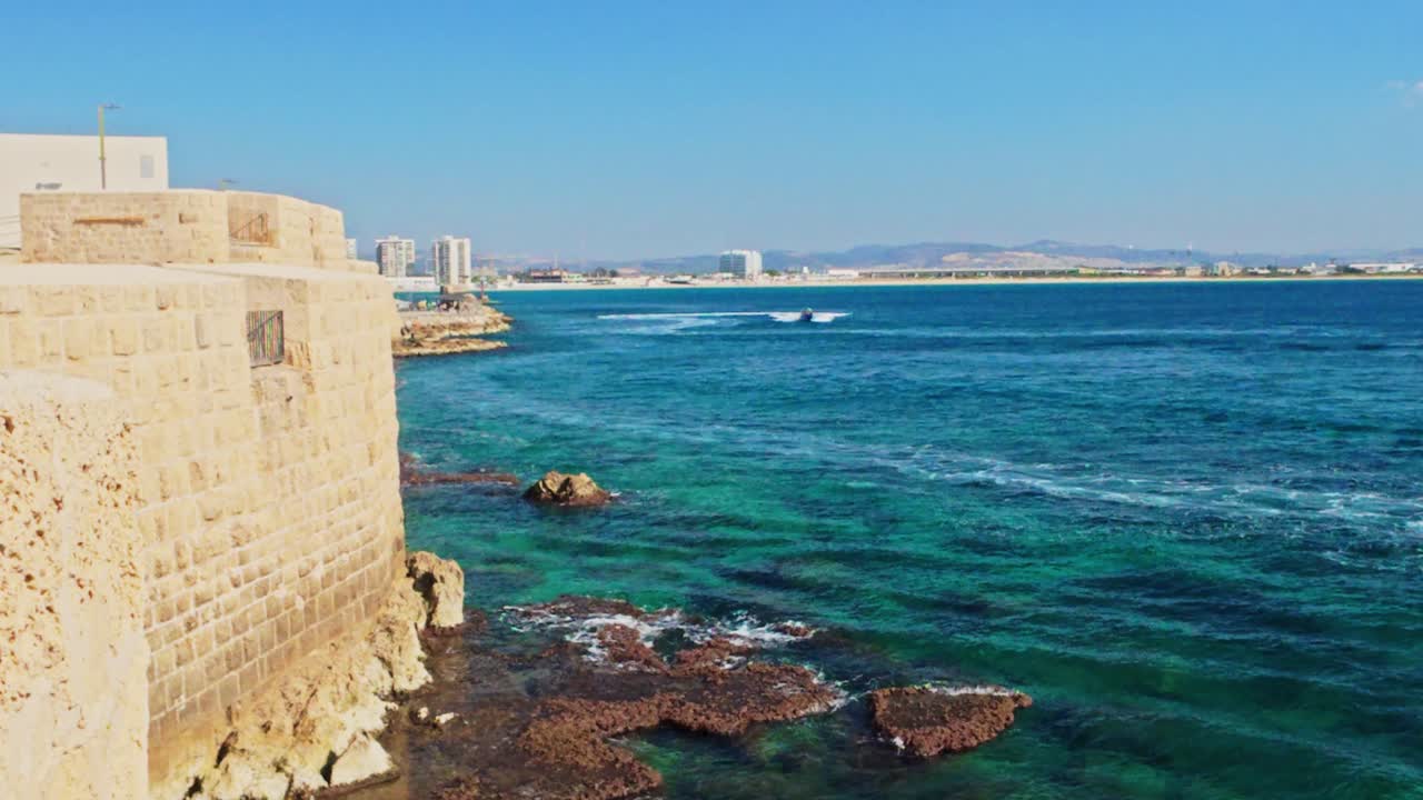 Bellissimo paesaggio marino con antiche fortificazioni e barca nella Vecchia Akko