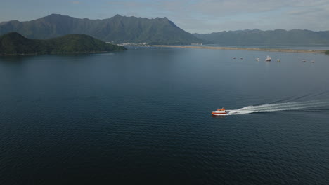 Drone-shot-of-tourism-Boat-on-the-water-in-the-city-in-Hong-Kong,-China