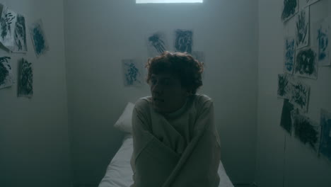 screaming patient trying to escape straitjacket in asylum isolation room