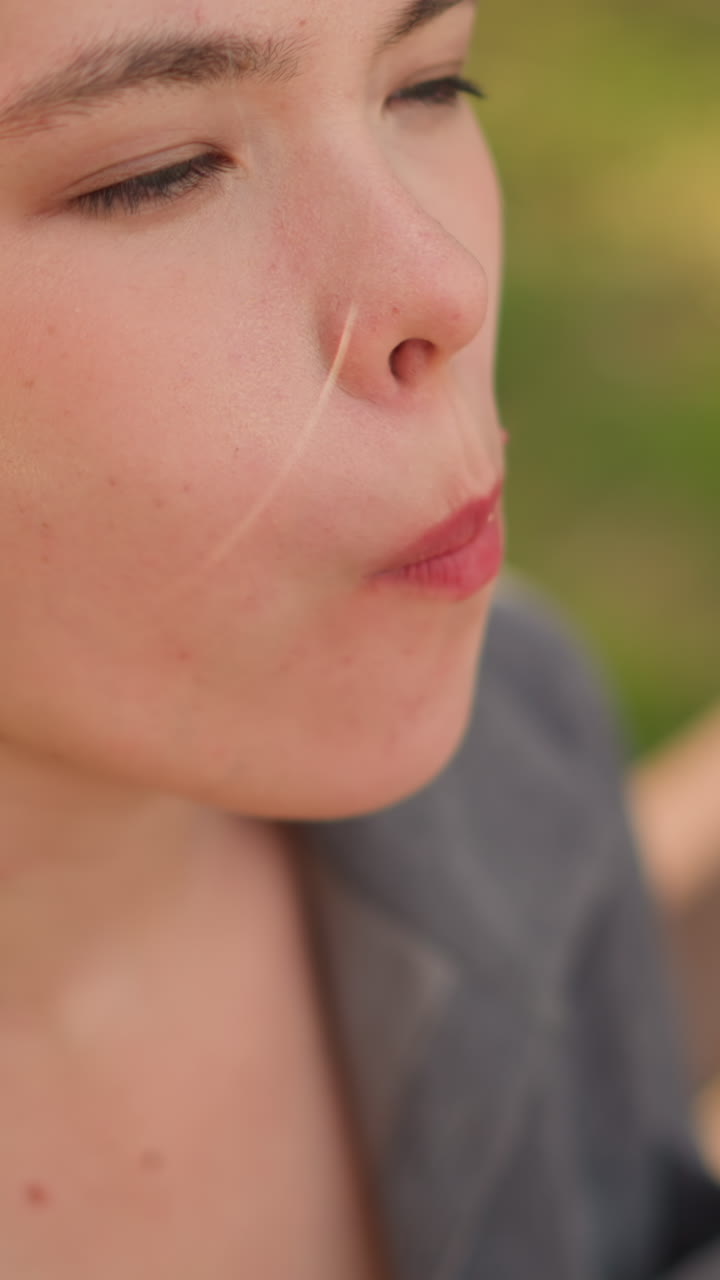 primer plano de alguien tomando un bocado de shawarma, centrándose en la mano que sostiene el sándwich y el momento de comer, con un fondo borroso en un entorno al aire libre